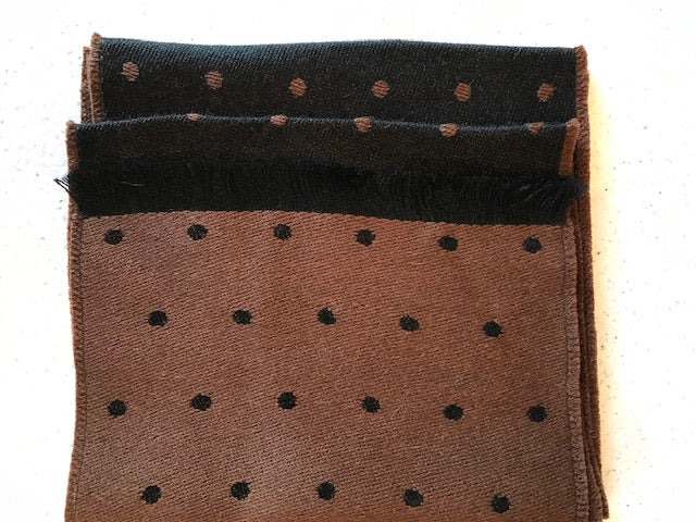 Alpaca fleece is lustrous and silky. It is similar to sheep's wool but it is warmer, not prickly, and contains no lanolin, which makes it hypoallergenic. Alpaca garments are soft and luxurious. This reversible two-sided black and brown scarf is hand-crafted in Peru by native artisans using 50% alpaca and 50% acrylic (for strength)